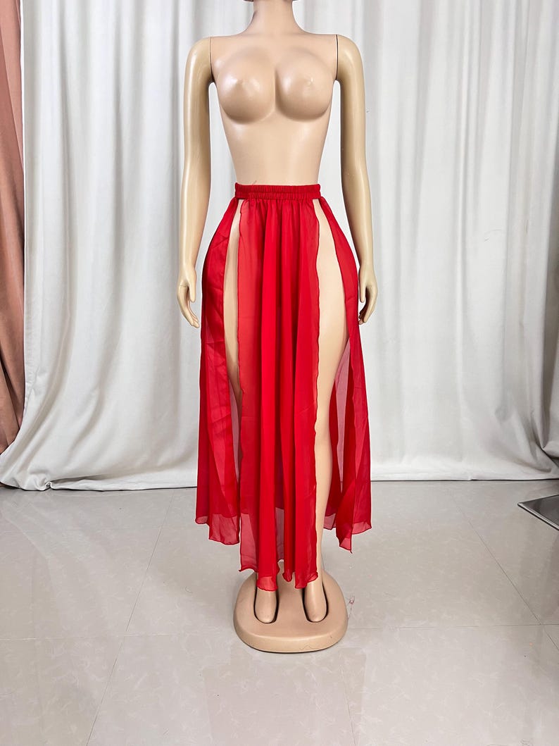 Puede incluir: Una falda larga de gasa roja con dos aberturas altas en la parte delantera. La falda est&aacute; en un maniqu&iacute;.