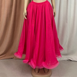 May include: A bright pink, flowing chiffon skirt with a gathered waistband. The skirt is long and full, with a layered design.