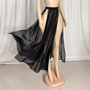 Puede incluir: Una falda maxi negra transparente con una abertura alta en la parte delantera. La falda est&aacute; hecha de una tela ligera y fluida y tiene un dise&ntilde;o simple y elegante.