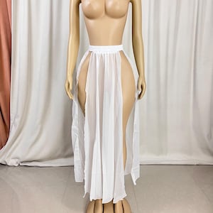 Puede incluir: Falda maxi blanca transparente con cintura alta y dos aberturas en los lados. La falda est&aacute; hecha de una tela ligera y fluida.