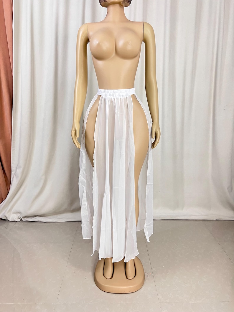 Puede incluir: Falda maxi blanca transparente con cintura alta y dos aberturas en los lados. La falda est&aacute; hecha de una tela ligera y fluida.