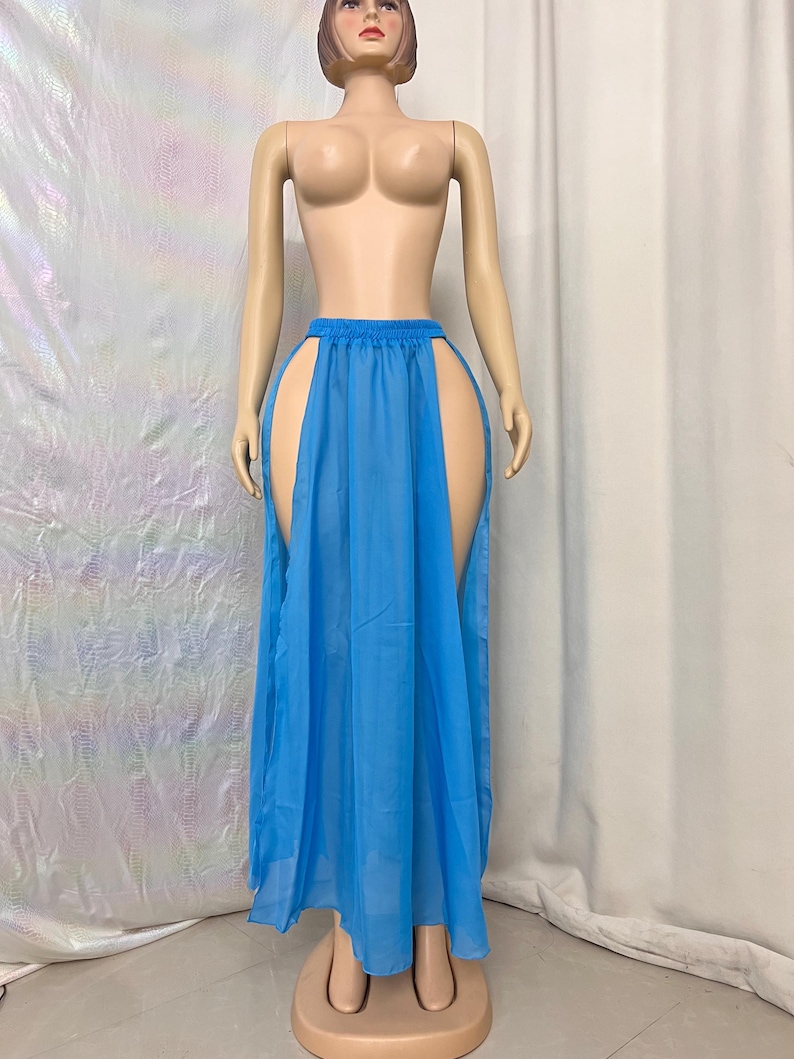 Puede incluir: Una falda maxi azul claro con dos aberturas altas a los lados. La falda est&aacute; hecha de una tela transparente y tiene un dise&ntilde;o simple y fluido.