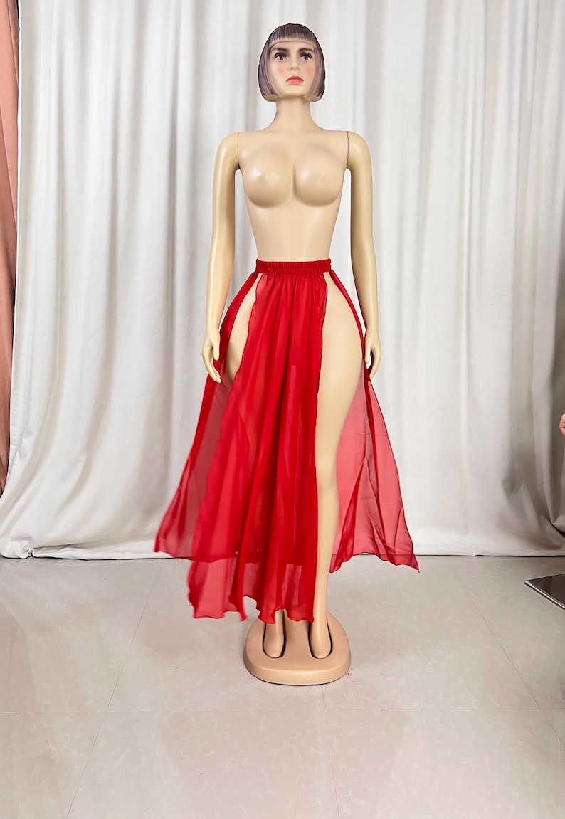 Puede incluir: Una falda maxi roja de gasa con una abertura alta a cada lado. La falda est&aacute; hecha de una tela ligera y tiene una silueta fluida.