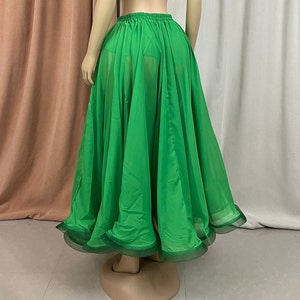 May include: A bright green, flowing chiffon skirt with a ruffled hem. The skirt is gathered at the waist and has a sheer, flowing fabric.