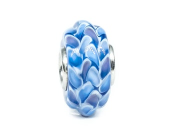 Op de afbeelding: Een blauwe en witte glazen kralen met een draaiende patroon. De kraal is gemaakt van glas en heeft een zilveren metalen kern.