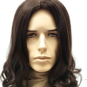 Puede incluir: Cabeza de maniquí con peluca castaña. La peluca presenta cabello largo y ondulado con una raya natural. El maniquí tiene una expresión neutra y está sobre un fondo blanco.