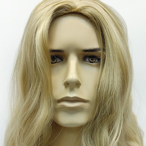 Peut inclure: Une perruque longue et ondul&eacute;e, blonde clair, sur une t&ecirc;te de mannequin. La perruque a un style en couches d'apparence naturelle.