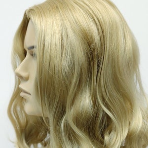 Peut inclure: Une perruque blonde avec des cheveux ondul&eacute;s coiff&eacute;s en un bob mi-long.