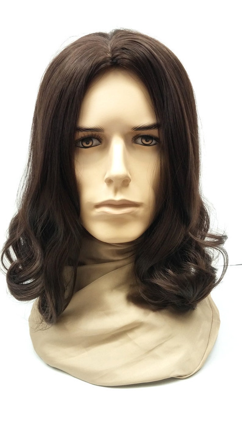 May include: A mannequin head with a brown wig. The wig features long, wavy hair with a natural-looking part. The mannequin has a neutral expression and is set against a white background.