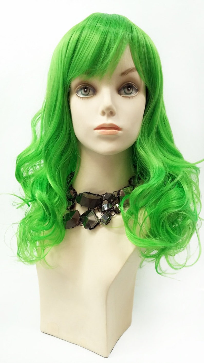 May include: A bright green wig with long, wavy hair and a side part. The wig is styled with a fringe and has a natural-looking finish.