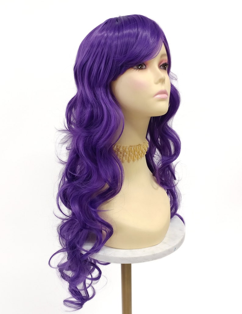 May include: A long, wavy purple wig with side-swept bangs. The wig is styled in loose curls and is worn on a mannequin head.