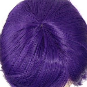 May include: A purple wig with short, straight hair. The wig is styled with a side part and has a natural-looking hairline.
