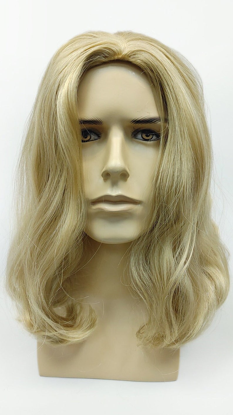 Peut inclure: Une perruque longue et ondul&eacute;e, blonde clair, sur une t&ecirc;te de mannequin. La perruque a un style en couches d'apparence naturelle.