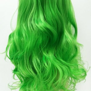 May include: A bright green wig with long, wavy hair. The wig is styled in a loose, flowing manner and is displayed on a mannequin head.