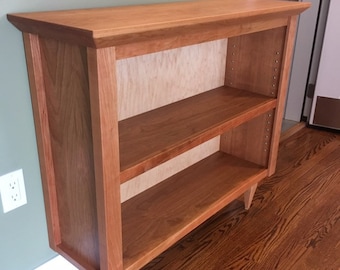 Cherry bookcase with solid cherry top and tapered legs. Solid cherry accents