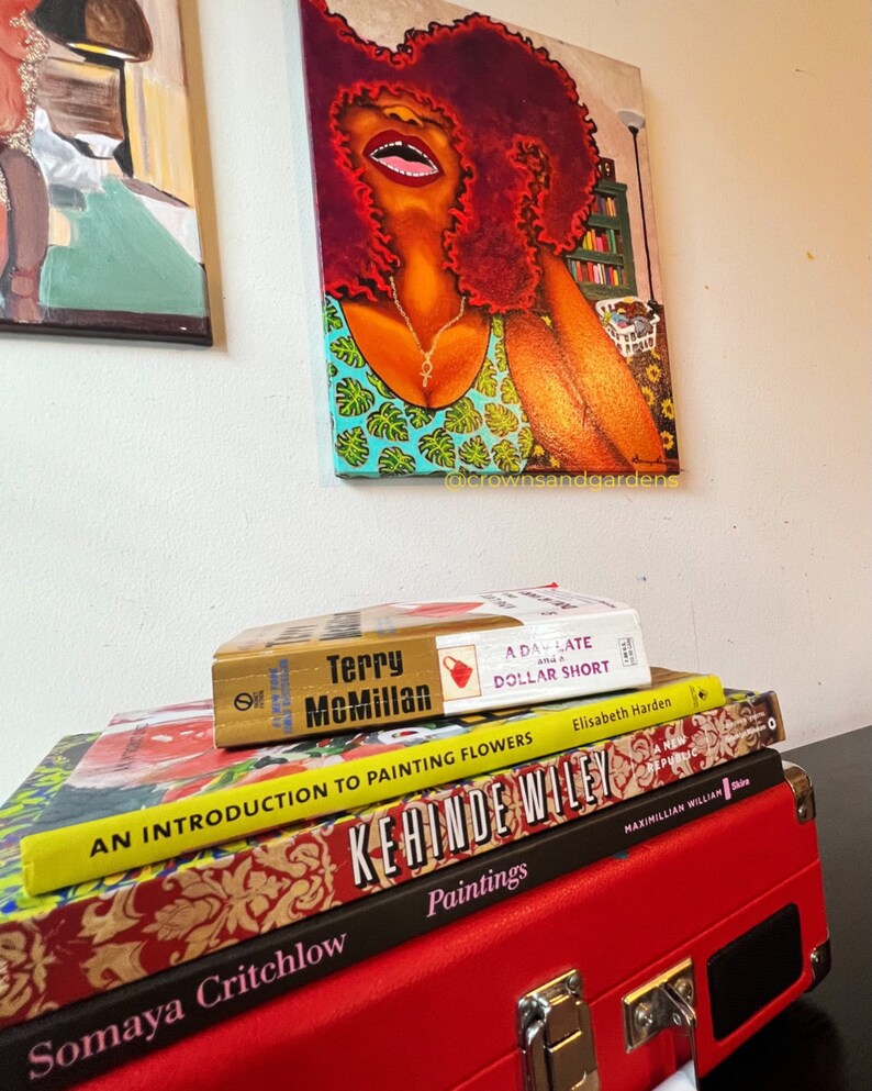 May include: A stack of four books with colorful covers. The top book is titled "A Day Late and a Dollar Short" by Terry McMillan. The second book is titled "An Introduction to Painting Flowers" by Elisabeth Harden. The third book is titled "Kehinde Wiley" and the fourth book is titled "Somaya Critchlow Paintings".