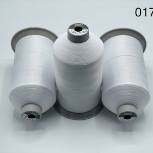May include: Three spools of white Coats thread, each with a grey label that reads "COATS" and "01712".