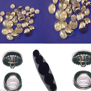 May include: A set of silver-colored metal buttons with a decorative edge. The buttons are arranged in a pile on a blue surface. There are also two metal button press tools, one with a black handle and the other with a silver handle.