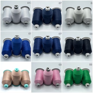 May include: Nine spools of thread in various colours, including white, blue, beige, pink, and green. The spools are arranged in three rows of three.