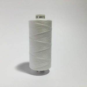 May include: A white spool of thread with the text "120 WHITE" printed on the label.