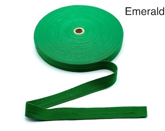 May include: A roll of emerald green cotton twill tape. The tape is woven with a herringbone pattern and is approximately 1 inch wide.