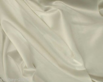 May include: A smooth, off-white fabric with a soft, silky texture. The fabric is draped and folded, creating a luxurious and elegant look.