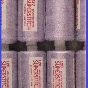 Peut inclure: Six bobines de fil de couleur lilas étiquetées "120 Spun Polyester Superstitch 914 mètres (1000 yds)"