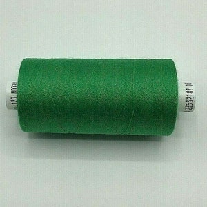 May include: A spool of green thread with white labels that read "120 m" and "20552187 W".