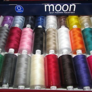 May include: A box of Coats Moon Spun Polyester Assortment thread spools in various colors, including red, pink, black, beige, white, orange, green, gray, cream, dark red, brown, navy blue, and hot pink.