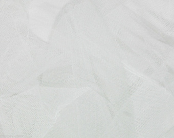 May include: White tulle fabric with a delicate, fine mesh texture. The fabric is soft and sheer, with a slightly crinkled appearance.