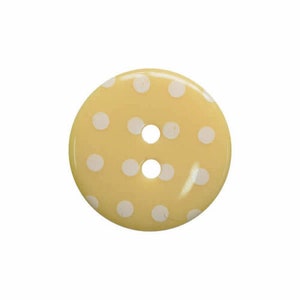 Peut inclure: Un bouton jaune avec des pois blancs. Le bouton a deux trous.