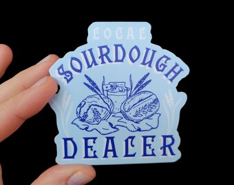May include: Blue and white sticker with the text "Local Sourdough Dealer" in a stylized font. The sticker features a drawing of two loaves of bread, a jar of sourdough starter, and wheat stalks.
