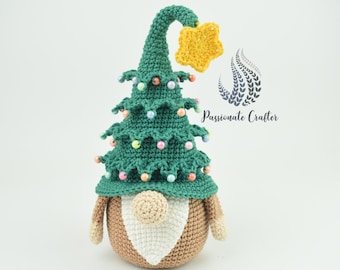 Puede incluir: Un gnomo de árbol de Navidad de crochet con un sombrero verde, una estrella amarilla en la parte superior y cuentas de colores para adornos. El gnomo tiene un cuerpo marrón, una barba blanca y una nariz beige.