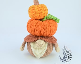 May include: A crocheted gnome wearing a stack of three orange pumpkins. The gnome has a brown hat and a white beard.