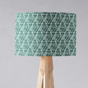 May include: A green and white geometric patterned lampshade with a wooden tripod stand.