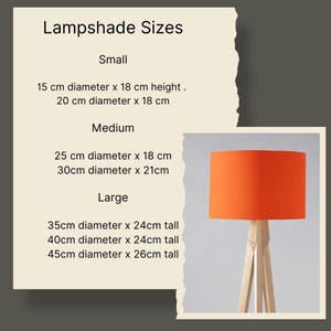 May include: A chart showing different lampshade sizes in centimeters. The chart lists the diameter and height of each size. A bright orange lampshade is shown on a wooden tripod stand.