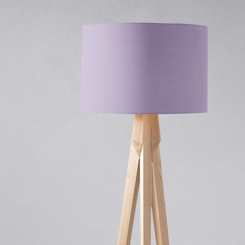 May include: A tripod floor lamp with a light purple fabric lampshade.