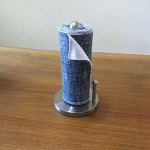 May include: A stainless steel paper towel holder with a blue and white patterned paper towel roll.