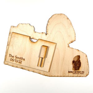K&ouml;nnte beinhalten: Eine Holzplakette mit einem Ausschnitt f&uuml;r eine Schallplatte. Die Plakette ist mit "The Smiths 05/13/22" und "NOBLE INTENT CO. Granbury, Texas" graviert. Im unteren rechten Eck ist ein Totenkopf graviert.