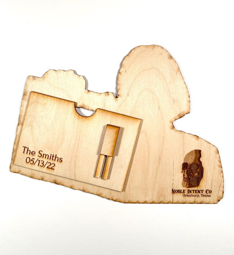 K&ouml;nnte beinhalten: Eine Holzplakette mit einem Ausschnitt f&uuml;r eine Schallplatte. Die Plakette ist mit "The Smiths 05/13/22" und "NOBLE INTENT CO. Granbury, Texas" graviert. Im unteren rechten Eck ist ein Totenkopf graviert.