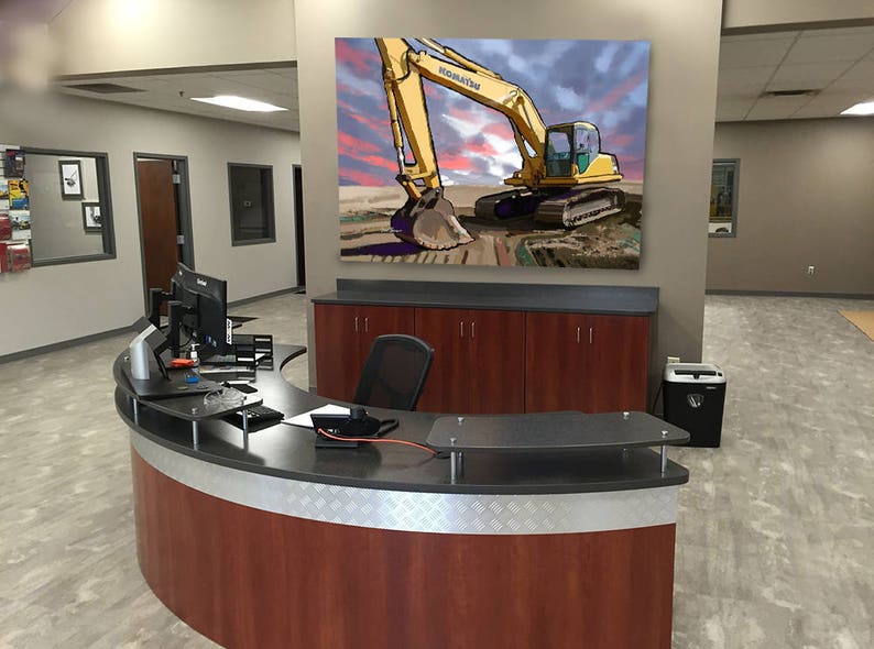K&ouml;nnte beinhalten: Ein gelber Bagger mit der Aufschrift "KOMATSU" an der Seite ist in einem Gem&auml;lde an einer Wand in einem Gesch&auml;ftsb&uuml;ro zu sehen. Der Bagger gr&auml;bt im Dreck. Das Gem&auml;lde befindet sich &uuml;ber einem dunklen Holzkasten mit einem geschwungenen Empfangstresen davor.
