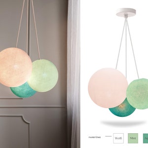 May include: A three-light pendant lamp with cotton ball shades in white, mint green, and aqua blue. The lamp is hanging from a white ceiling fixture.