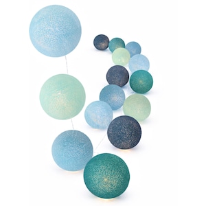 Op de afbeelding: Een lichtsnoer met bolvormige lampen in een verloop van blauwe en groene tinten. De bollen zijn gemaakt van een getextureerd, geweven materiaal dat het licht verspreidt, variërend van licht hemelsblauw en mintgroen tot donker marineblauw en groenblauw.