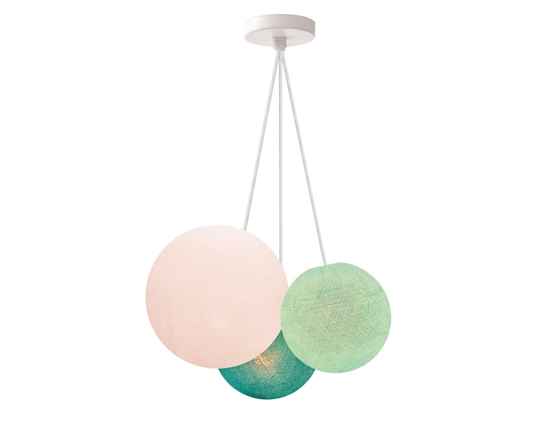 May include: A white ceiling light fixture with three hanging cotton ball shades. The shades are pink, green, and teal.
