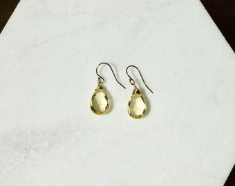 May include: A pair of gold earrings with teardrop-shaped yellow citrine stones.