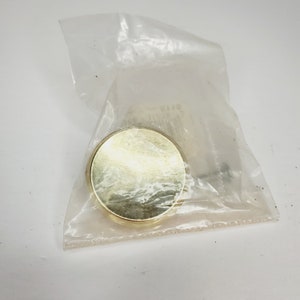 May include: A gold round cabinet knob with a screw.