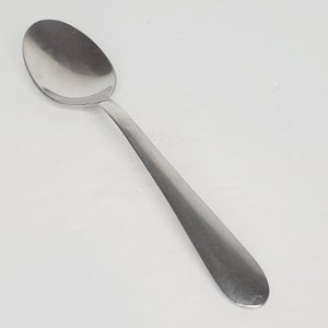May include: A silver spoon with a rounded bowl and a long, slender handle.
