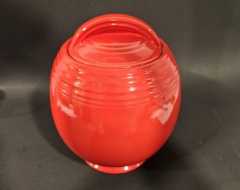 Tarro de galletas de cerámica roja china con arañazos y astillas de madera.