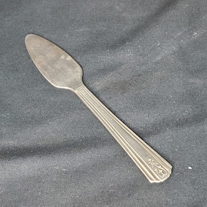 May include: A silver butter knife with a decorative design on the handle.