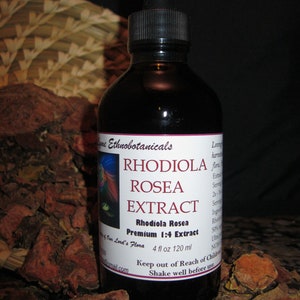 May include: A dark brown glass bottle with a dropper top, labeled "Rhodiola Rosea Extract". The bottle is sitting on a bed of brown, dried, and broken pieces of root bark. The label also says "Premium 1:4 Extract" and "4 fl oz 120 ml".